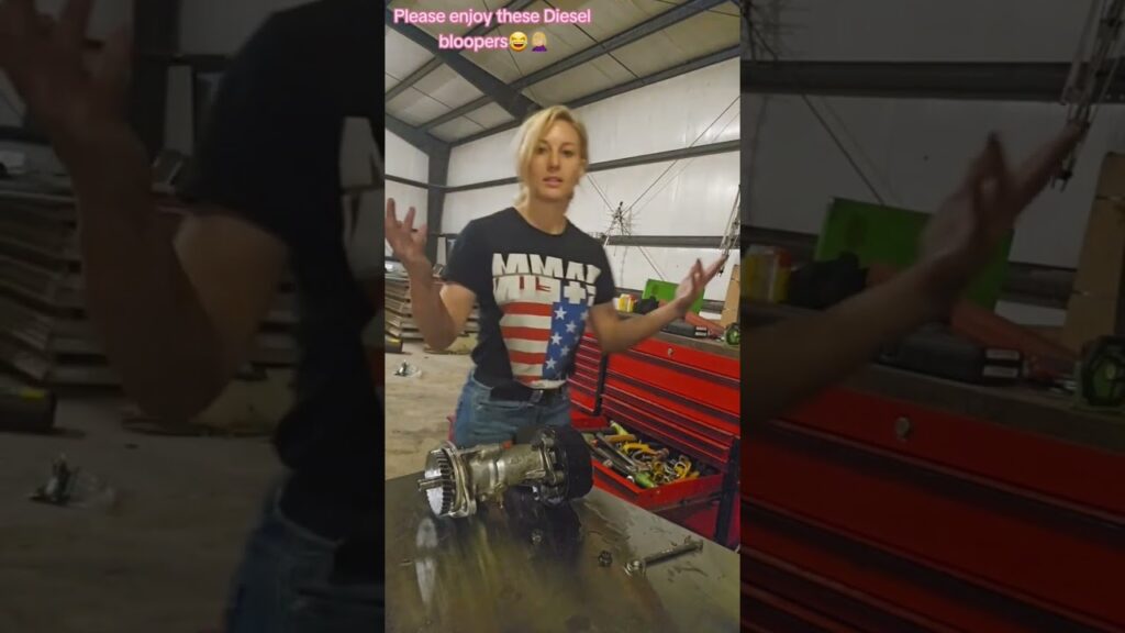 A person in a shirt with an MMA logo stands in a garage-like setting, gesturing with their hands. A mechanical part lies on the workbench in front of them. Text above reads, "Please enjoy these Diesel bloopers 🤪.