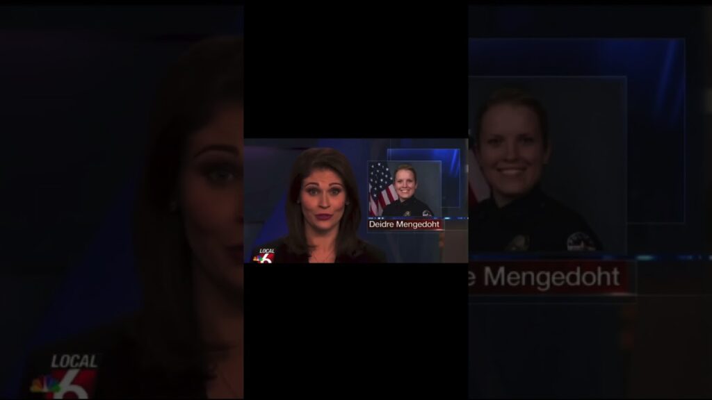 A news broadcast screenshot featuring a female news anchor on the left with a small inset image of a smiling police officer with an American flag background on the right. The names "Deidre Mengedoht" and "Local 6" are visible.