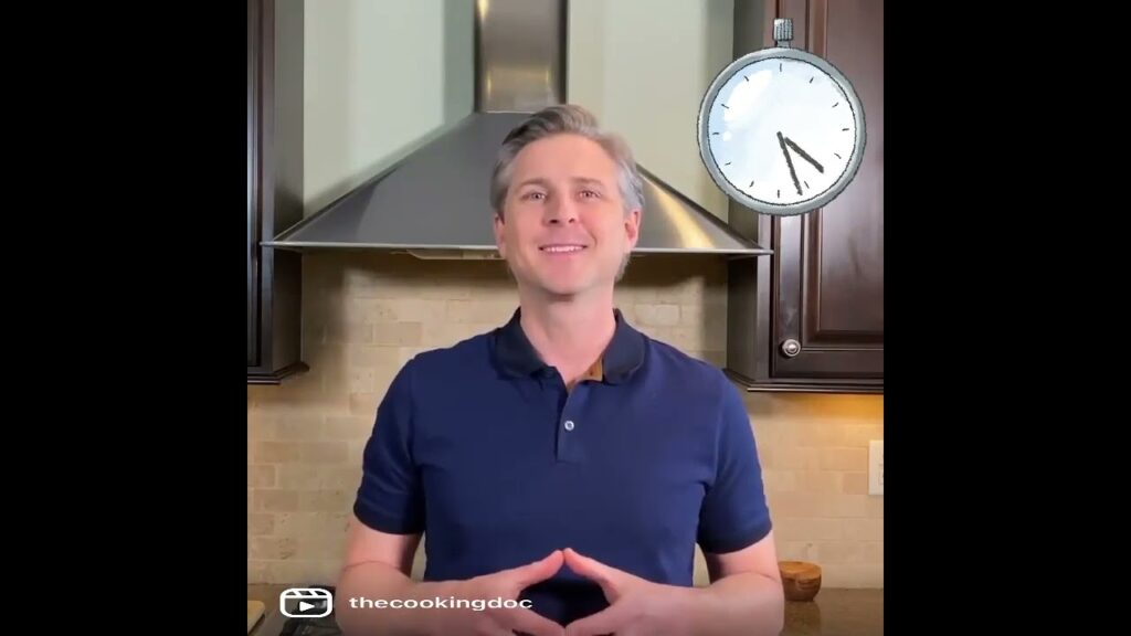 A person in a blue polo shirt stands in a kitchen with dark cabinets and a stainless steel range hood. A clock graphic is overlaid in the top right corner, showing 10 o'clock.