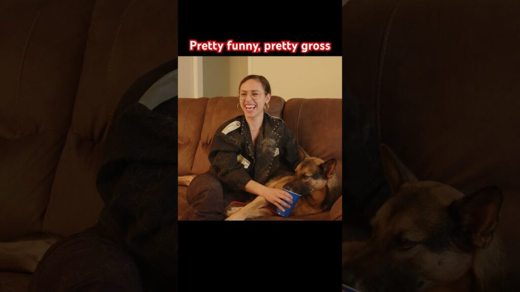 A person sitting on a brown couch, smiling, with a dog resting its head on their lap. They are holding a blue cup. The text above reads, "Pretty funny, pretty gross.